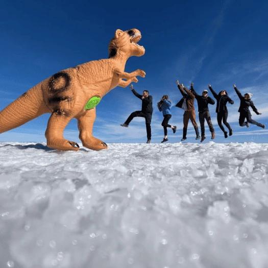 Group punching a dinosaur perspective photo on the Uyuni Salt Flat