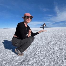Cat holding Alice in the palm of her hand perspective photo on the Uyuni Salt Flat