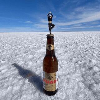 Cat in the yoga pose atop a beer bottle perspective photo on the Uyuni Salt Flat