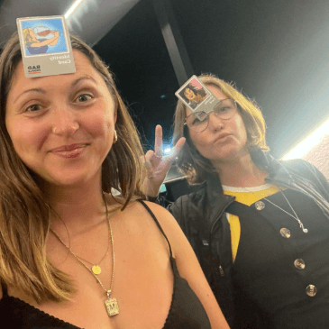 Cat and a travel friend with cards stuck on their forehead for a game