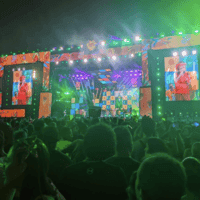 Big crowd in front of a large stage with a performer