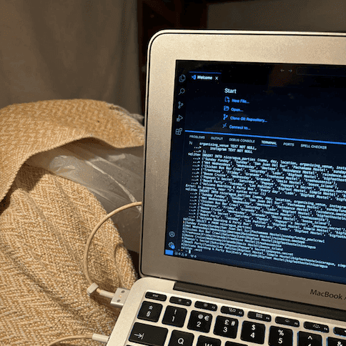 Photo of a laptop next to a bag of ice on a blanket on a knee