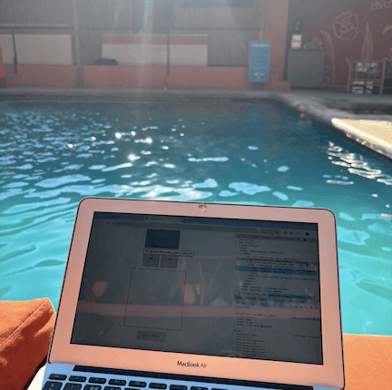 Laptop pictured on the side of a pool