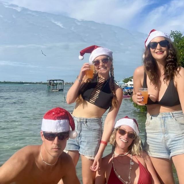 4 people pictured with santa hats