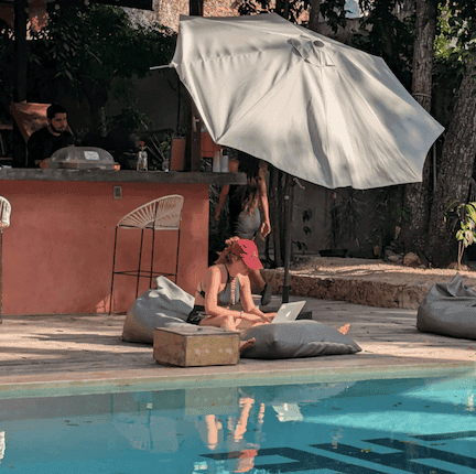Cat pictured on her laptop at the side of a pool