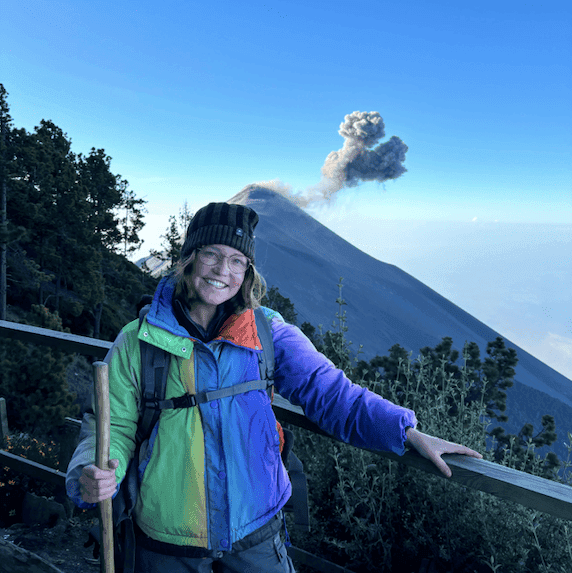Cat pictured bundled up in front of an active volcano