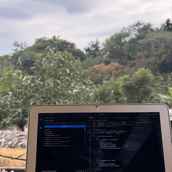 Laptop pictured in front of lots of greenery