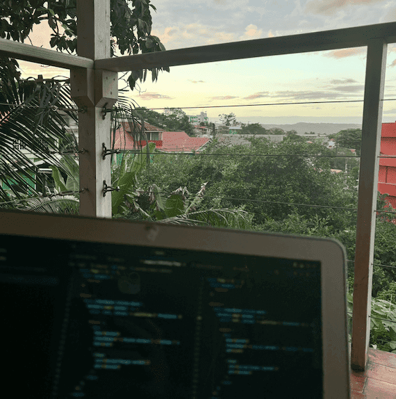 Laptop pictured with a sunset view from a veranda